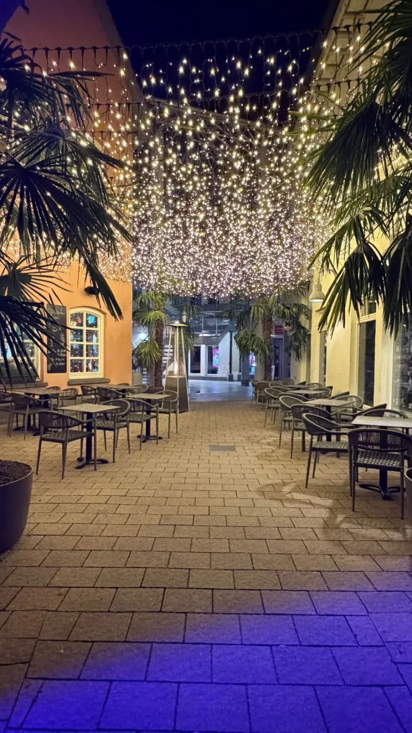 Beleuchteter Außenbereich der Jungle Bar in der Höllturm-Passage Radolfzell mit Lichterhimmel und Palmen
